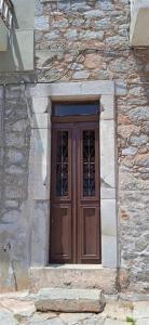 a wooden door on the side of a stone building at The Island sea view apartment in Elounda