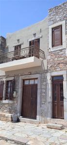 a stone building with two doors and a balcony at The Island sea view apartment in Elounda