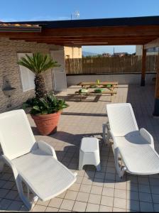 two white chairs and a picnic table on a patio at myrooftop a 10 min dalla Reggia di Caserta in Caserta