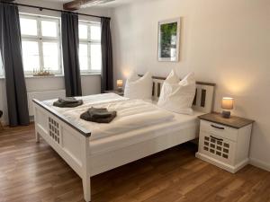 a bedroom with a white bed with two towels on it at Zum Mathildenbrunnen in Quedlinburg