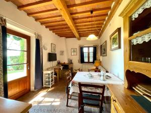 una sala da pranzo con tavolo, sedie e finestra di Podere Morena with sea view, private garden, by ToscanaTour Luca a Guardistallo