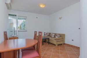 a living room with a table and a couch at Apartments Riva Medulin in Medulin