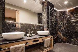 a bathroom with two sinks and a large shower at Apartments Belaval in Santa Cristina Gherdëina