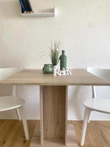 un tavolo in legno con una pianta e una bottiglia di Appartement Universität Mainz a Magonza