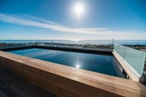 
a large swimming pool with a view of the ocean at Hotel Port Toga in Bastia
