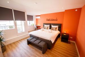 a bedroom with orange walls and a bed and a window at Trendy Design 55m2 Apartment with Balcony in Den Bosch