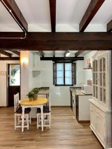 a kitchen with a wooden table and a dining room at Apartamentos Río Cubo in Cosgaya