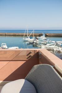 une chaise assise au-dessus d'un balcon avec port de plaisance dans l'établissement Avra Apartments Venetian Harbour, à La Canée