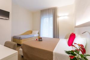a hotel room with a bed and a couch at Hotel Amicizia in Rimini