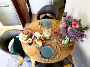 uma mesa de madeira com pratos de comida e flores em Apartmany Ivana em Děčín