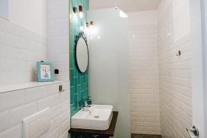 W białej łazience znajduje się umywalka i lustro. w obiekcie Old Citadel Hill Apartment w Braszowie