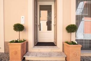 une porte d'entrée d'une maison avec deux plantes en pot dans l'établissement Antico Borgo B&B, à Cannobio