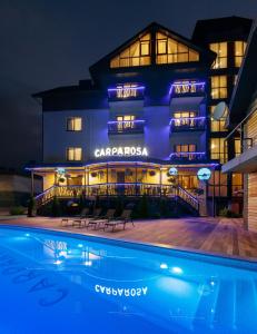 un hotel con piscina por la noche en Carparosa Hotel en Bukovel