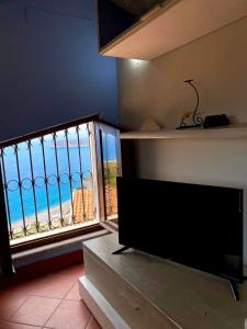 a living room with a television and a view of the ocean at La casa nel borgo in San Nicola Arcella