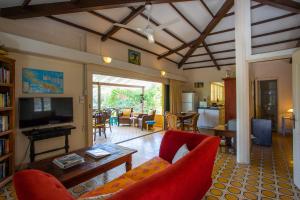 a living room with a red couch and a tv at Bungalow Hopi Bon in Willemstad