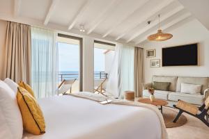 a hotel room with a large bed and a couch at Les Roches Brunes in Collioure