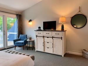 1 dormitorio con cama y vestidor con TV en Smuggler's Cove Inn en Boothbay