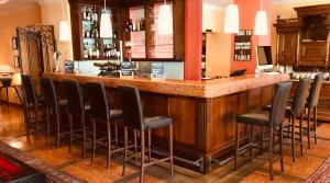 un bar con un montón de taburetes en una habitación en Strandhotel Margaretha, en St. Wolfgang