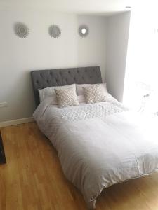 a bedroom with a large bed with white sheets and pillows at High gables Apartment 1 in Paignton