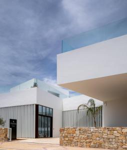 un edificio blanco con una pared de piedra en Hotel Porfirio Picota - Adults Recommended en Zahara de los Atunes