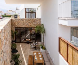 um pátio exterior com mesas e cadeiras num edifício em Hotel Porfirio Picota - Adults Recommended em Zahara de los Atunes