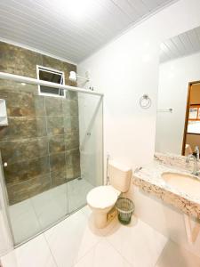 uma casa de banho com um chuveiro, um WC e um lavatório. em Hotel dos Sonhos em São Tomé das Letras