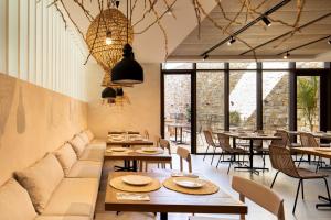 a restaurant with tables and chairs and windows at Hotel Porfirio Picota - Adults in Zahara de los Atunes