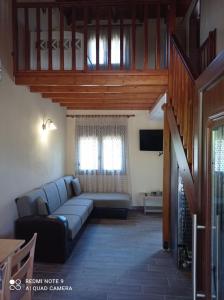 un soggiorno con divano blu e TV di Ioannis Stagkonis House 2 a Ormos Panagias