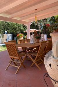 una mesa de madera y sillas bajo una pérgola en Villa Vittoria, en Vieste