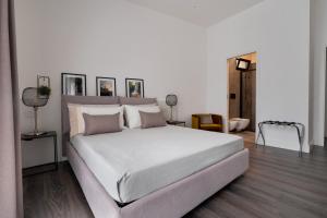 Un dormitorio con una gran cama blanca en una habitación. en Harmony Luxury Rooms, en Castellammare di Stabia 12 fotos más