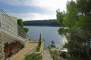 een boot ligt op het water naast een huis bij Beachfront Apartment in Tri Porte, with sea view, terrace, air conditioning, WiFi 5208-2 in Potirna +35 foto's