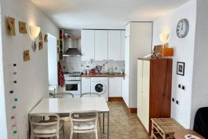 een keuken met een witte tafel en stoelen bij Framura, Ampio appartamento con terrazzo vista mare in Framura