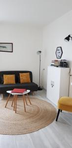 uma sala de estar com um sofá e uma mesa de centro em Appartement rétro au pied de Futuroscope em Chasseneuil-du-Poitou