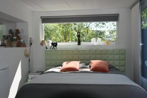 a bedroom with a bed with two pillows and a window at Naar Ineke in Doesburg