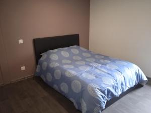 - une chambre avec un lit et une couette bleue et blanche dans l'établissement Au petit dormant, à Saint-Sauveur-en-Puisaye