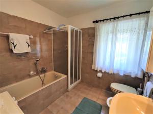 a bathroom with a tub and a toilet and a sink at Appartamento Lärchenwald - Trepalle in Livigno +25 photos
