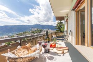 un tavolo con bicchieri di vino e cibo su un balcone di Apartment La Brunella a Laion
