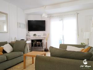 a living room with two couches and a tv at Cala Marqués Beach House in Vera