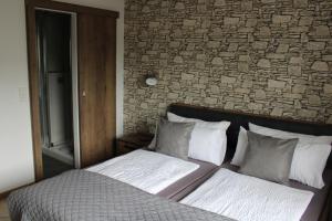 ein Bett in einem Schlafzimmer mit Ziegelwand in der Unterkunft Bachmeier's Gasthaus Traube Niederfell in Niederfell
