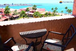 a table and chairs on a balcony with a view of the beach at Marina Pinacate C-518 in Puerto Peñasco