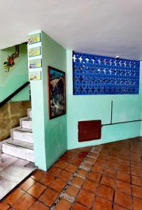 a room with stairs and a blue wall with a painting at The Roof Backpackers in Guadalajara