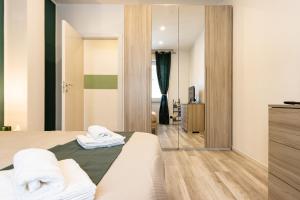 sypialnia z łóżkiem i lustrem w obiekcie Green Pearl ✰✰✰✰✰ Appartamento a 100 metri dal lago w mieście Arona