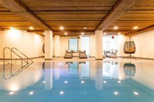 een zwembad in een huis met een houten plafond bij Genusshotel Diamant in Naturno