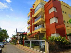un edificio rojo y amarillo en una calle de la ciudad en Res. Morada do Atobá, en Bombinhas