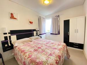Un dormitorio con una cama grande y una ventana en Res. Morada do Atobá, en Bombinhas