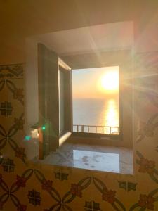 um quarto com uma janela com vista para o oceano em Residenza Porta di Mare em Castellabate