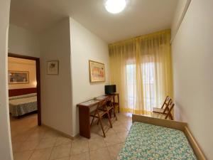 een kamer met een bed en een bureau met een computer bij Eden Appartamenti in Marina di Grosseto