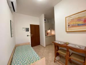 マリーナ・ディ・グロッセートにあるEden Appartamentiのベッドとテーブル付きの小さな部屋