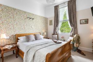 a bedroom with a large bed and a window at Abbeyfield Vintage Style Boutique B&B in Torquay