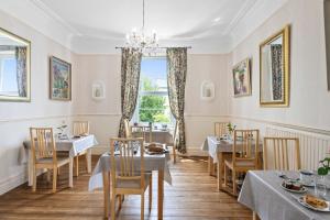 un comedor con mesas y sillas y una ventana en Abbeyfield Vintage Style Boutique B&B, en Torquay